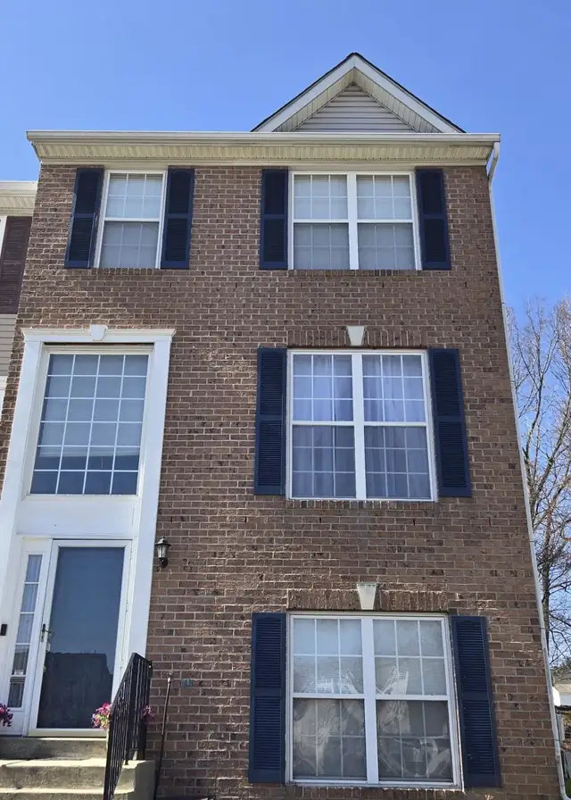 Brick townhouse with dark shutters that LMG washed, repainted and reinstalled